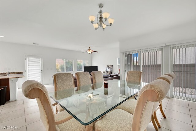 dining room featuring ceiling fan with notable chandelier and light tile patterned floors