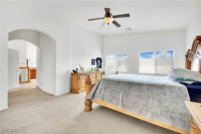 bedroom with light carpet, lofted ceiling, ensuite bathroom, and ceiling fan