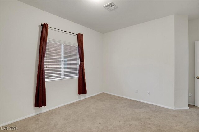 unfurnished room featuring light colored carpet