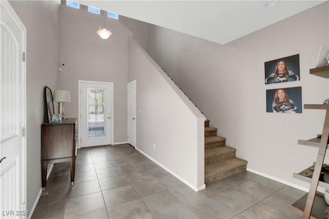 tiled entryway featuring a towering ceiling