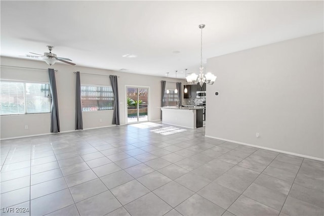 unfurnished living room with light tile patterned floors and ceiling fan with notable chandelier