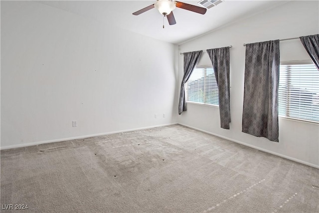 carpeted empty room featuring a healthy amount of sunlight, ceiling fan, and lofted ceiling