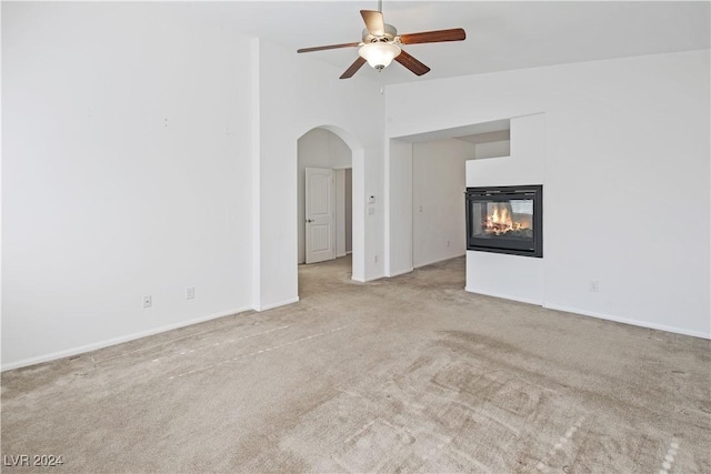 unfurnished living room with ceiling fan and light carpet