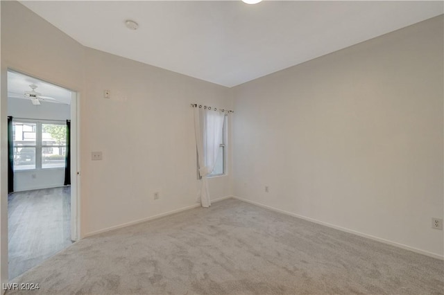 unfurnished room with light colored carpet, ceiling fan, and baseboards
