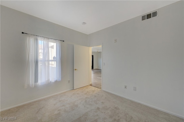 unfurnished room featuring light carpet