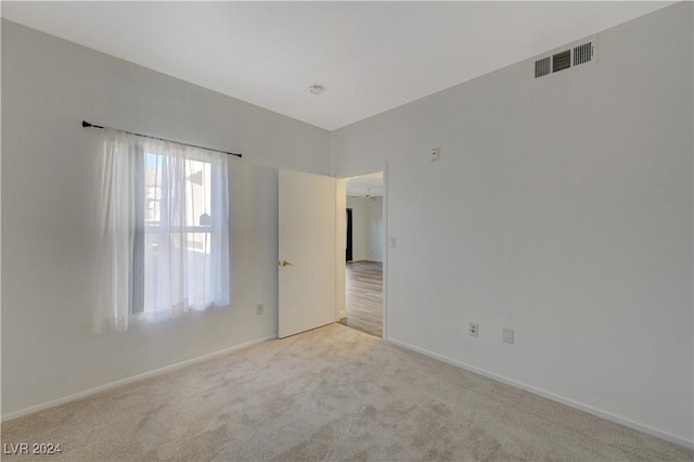 unfurnished room with baseboards, visible vents, and carpet
