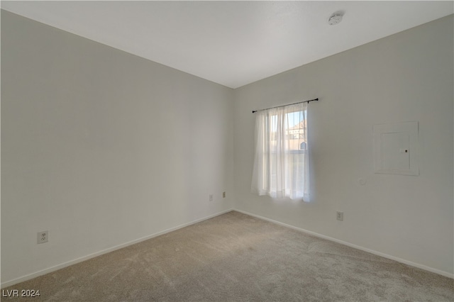 unfurnished room featuring light colored carpet and electric panel