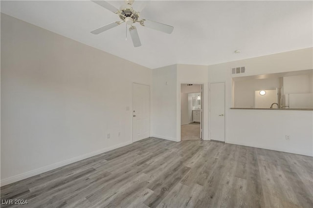 unfurnished living room with baseboards, ceiling fan, visible vents, and wood finished floors