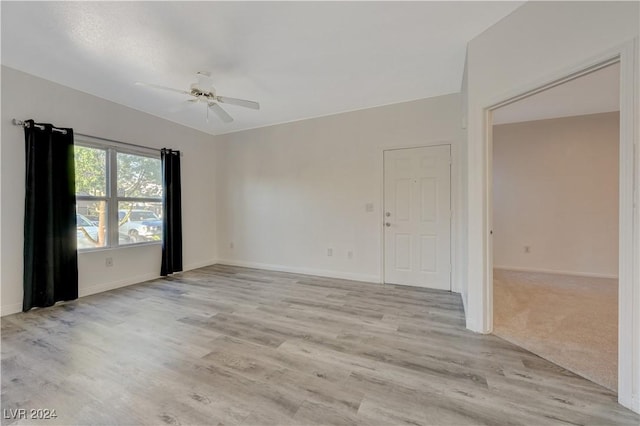 empty room with baseboards, light wood-style flooring, and ceiling fan