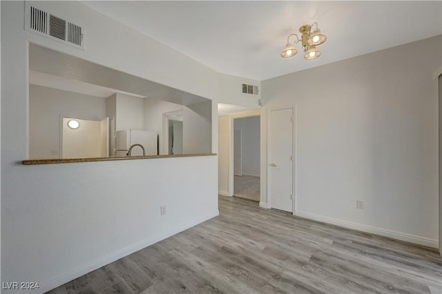 unfurnished living room featuring baseboards, visible vents, and wood finished floors