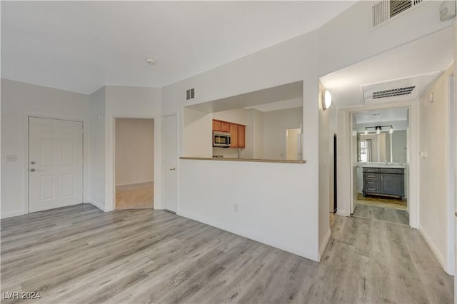 unfurnished living room featuring light wood-style flooring and visible vents