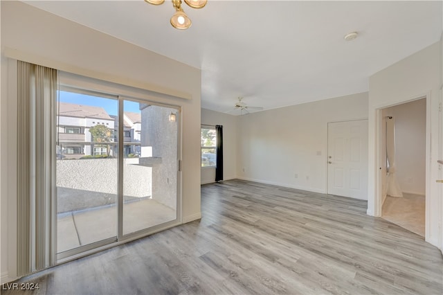 empty room with ceiling fan and light hardwood / wood-style floors