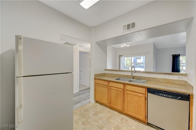 kitchen featuring light countertops, a sink, freestanding refrigerator, stainless steel dishwasher, and visible vents