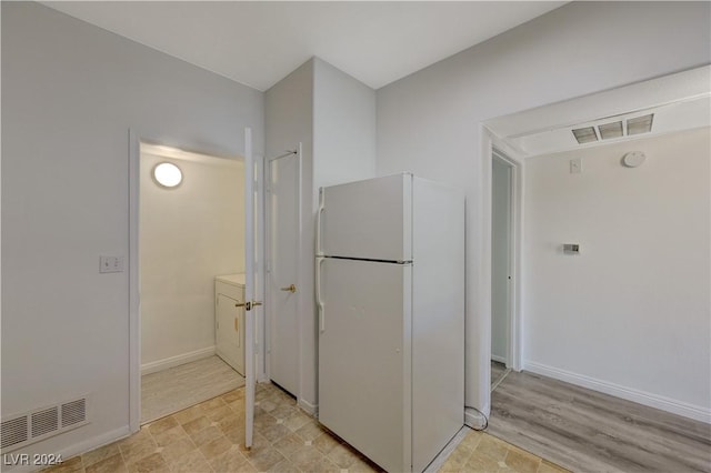 kitchen featuring freestanding refrigerator, washer / clothes dryer, baseboards, and visible vents