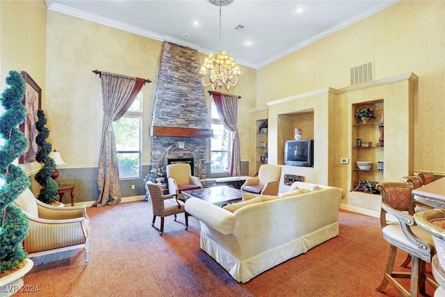 carpeted living room featuring a high ceiling, ornamental molding, built in shelves, a stone fireplace, and a chandelier