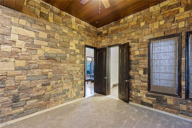 carpeted empty room with ceiling fan and wood ceiling