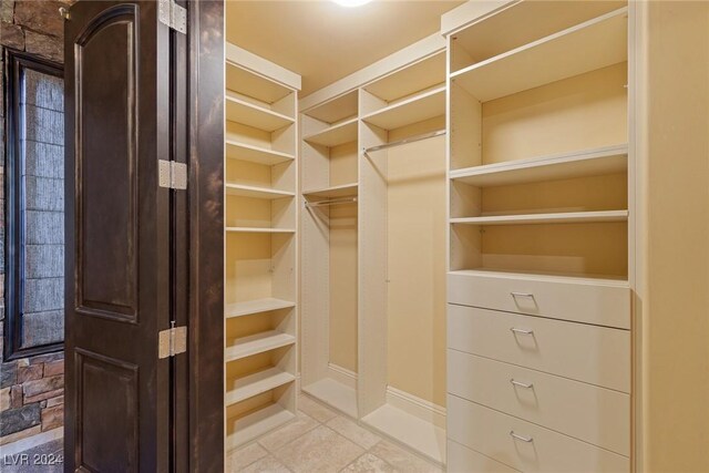 walk in closet featuring light tile patterned flooring