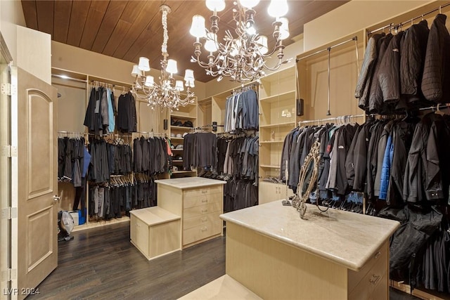 walk in closet featuring a notable chandelier and dark hardwood / wood-style floors