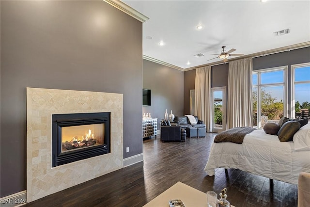 bedroom featuring ceiling fan, dark hardwood / wood-style floors, ornamental molding, and a fireplace