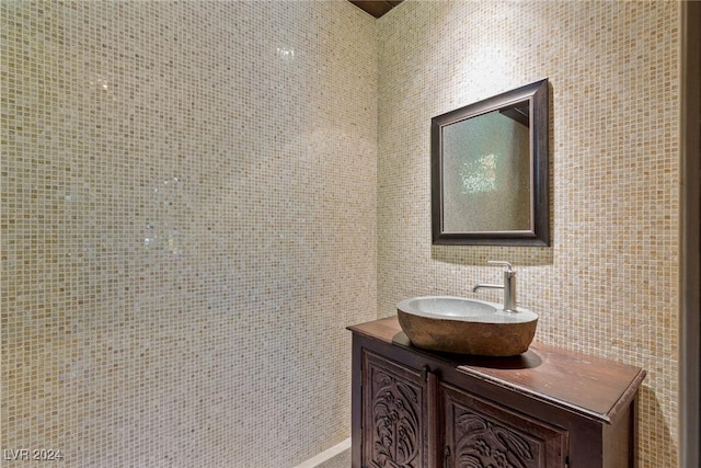 bathroom featuring vanity and tile walls