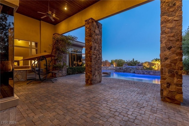 patio terrace at dusk with pool water feature and ceiling fan