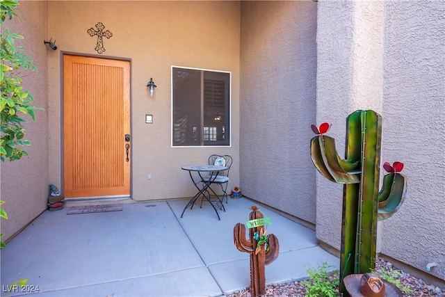 doorway to property featuring a patio area and stucco siding