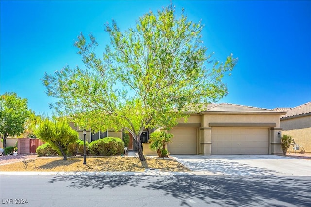 view of front of home with a garage, concrete driveway, a tiled roof, and stucco siding