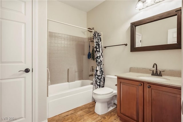 full bath with toilet, shower / tub combo with curtain, wood finished floors, and vanity