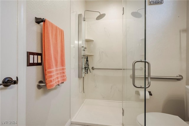 full bathroom featuring a shower stall and toilet