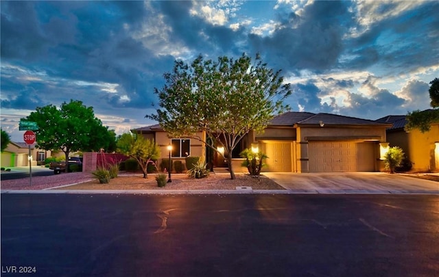 view of front of property with concrete driveway, an attached garage, and stucco siding