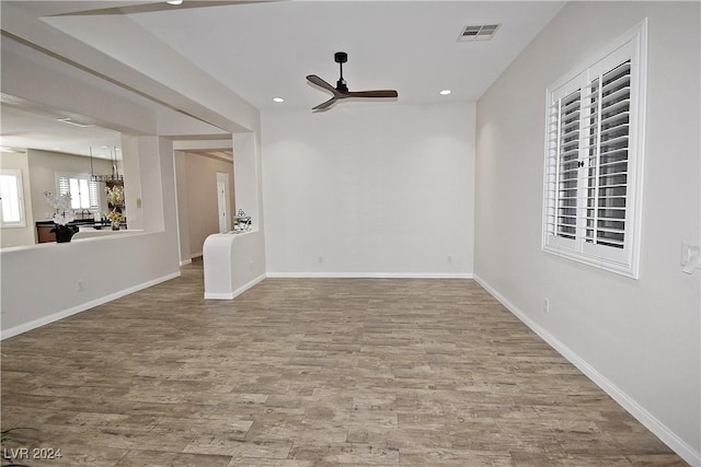 unfurnished room featuring recessed lighting, visible vents, a ceiling fan, wood finished floors, and baseboards