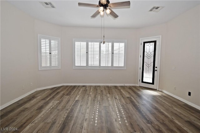 empty room with a ceiling fan, baseboards, visible vents, and wood finished floors