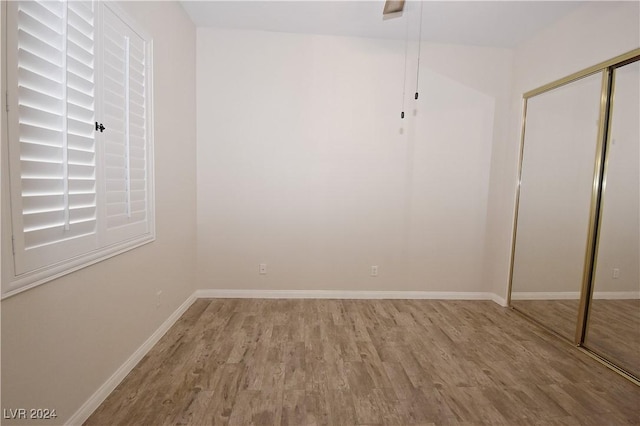 interior space featuring light wood-style floors, baseboards, and a closet