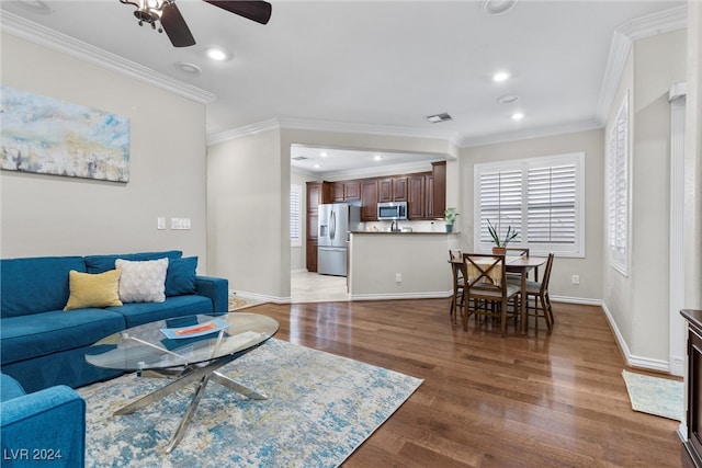 living room featuring ceiling fan, ornamental molding, and dark hardwood / wood-style floors