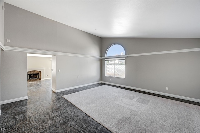 carpeted spare room with vaulted ceiling