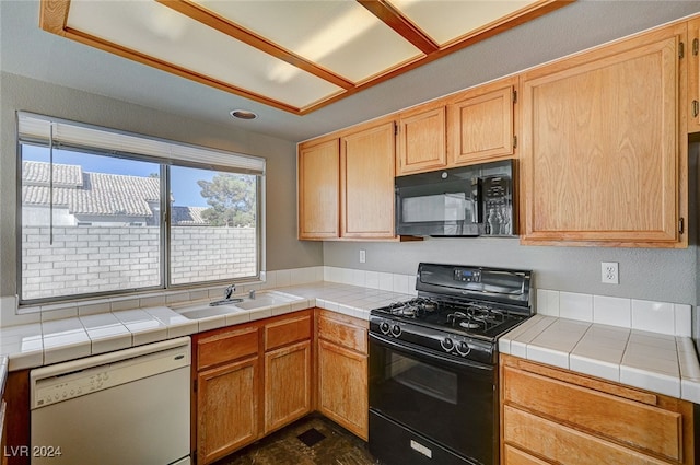 kitchen with tile countertops, black appliances, sink, and light brown cabinetry