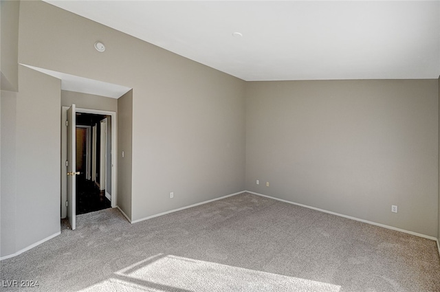 empty room with light carpet and vaulted ceiling