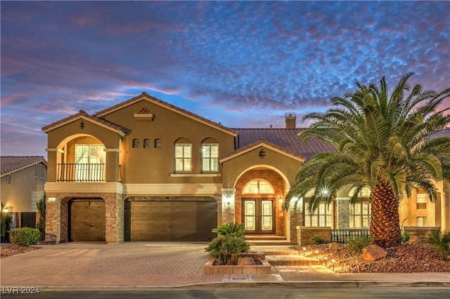 mediterranean / spanish house featuring a garage and french doors