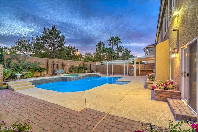 pool at dusk with a pergola, an in ground hot tub, and a patio