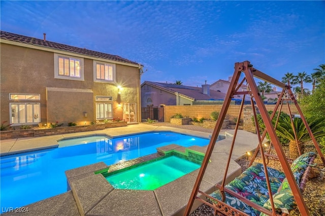 pool at dusk with a patio area