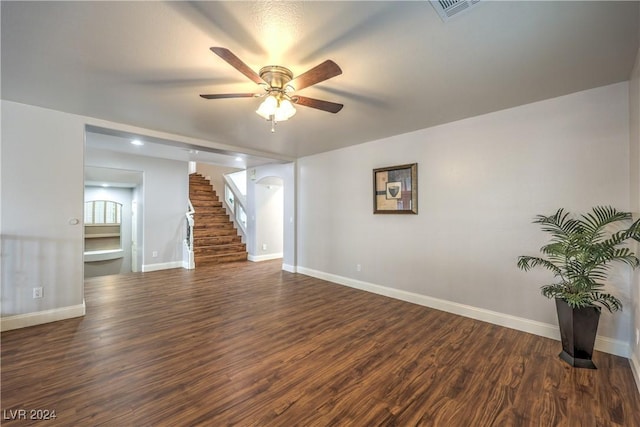 unfurnished living room featuring ceiling fan and dark wood-type flooring