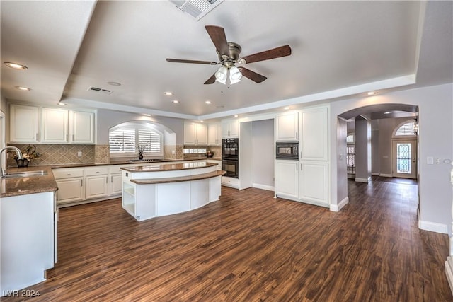 kitchen featuring white cabinetry, sink, dark hardwood / wood-style flooring, decorative backsplash, and black appliances