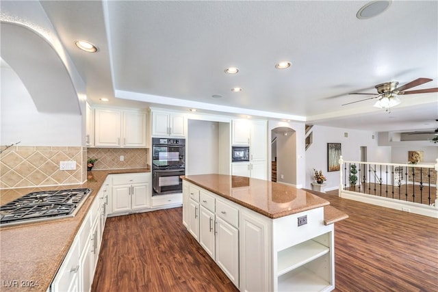 kitchen with a center island, black appliances, dark hardwood / wood-style floors, ceiling fan, and white cabinetry