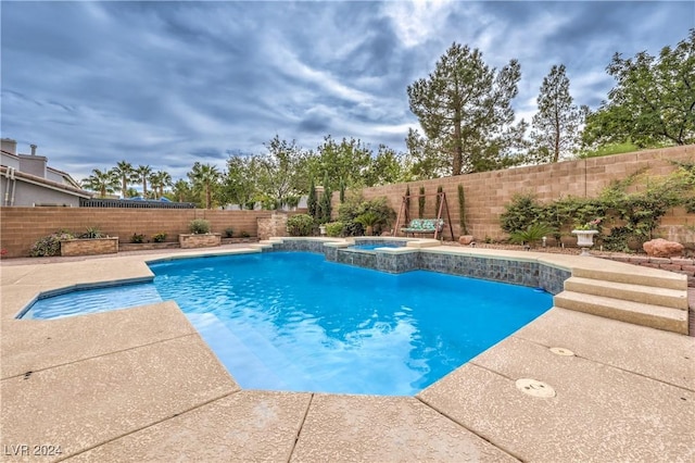 view of swimming pool with an in ground hot tub