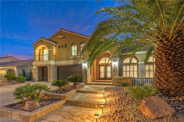 mediterranean / spanish-style home with a balcony and a garage