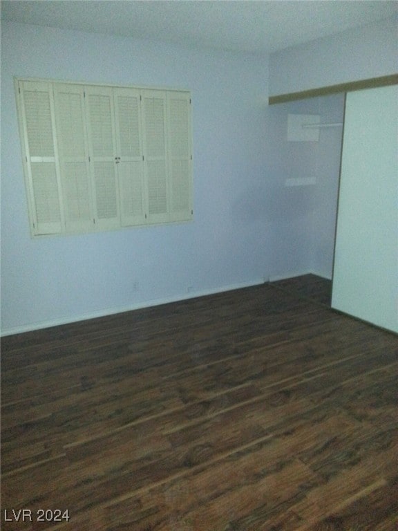 unfurnished room with dark wood-type flooring