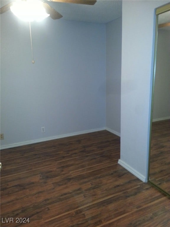 unfurnished room featuring ceiling fan and dark wood-type flooring