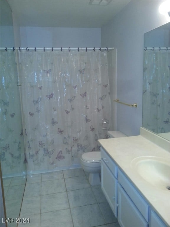 bathroom with tile patterned floors, vanity, curtained shower, and toilet