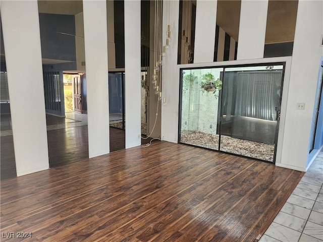 unfurnished room featuring a towering ceiling and light wood-type flooring