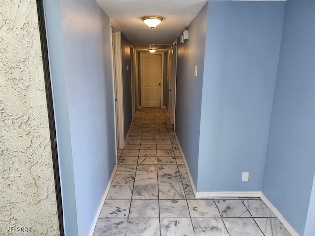 hall with a textured ceiling